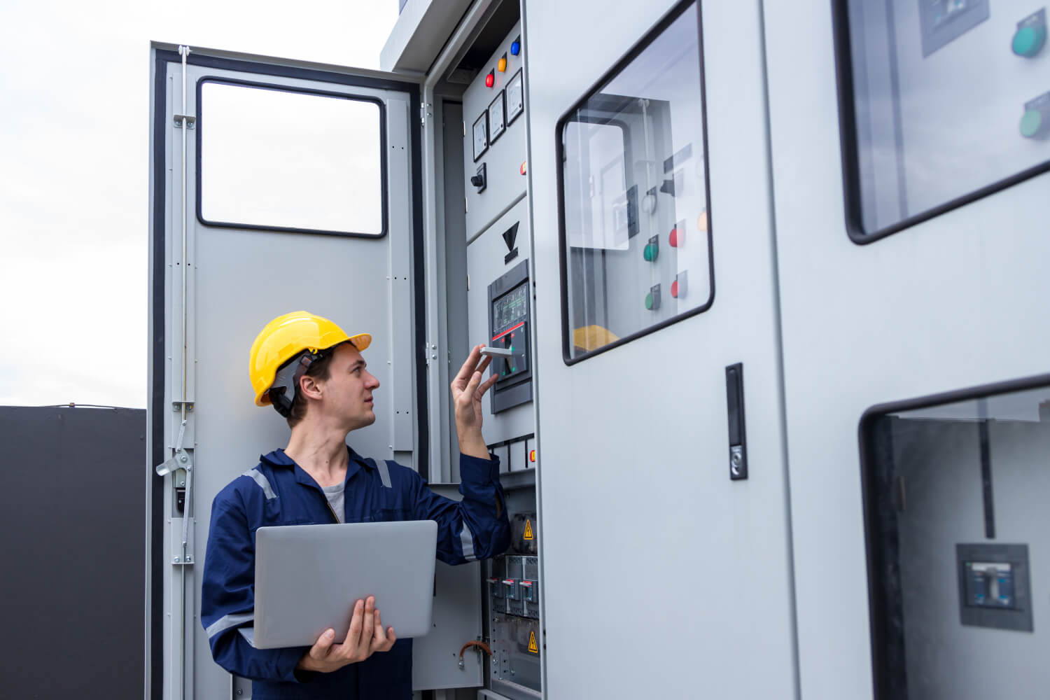 Person standing in front of generator electrical switchgear